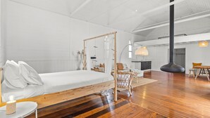 Una habitación amplia con una cama grande, un comedor y una cocina.