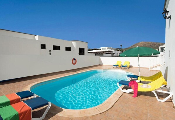 A rooftop swimming pool with lounge chairs and a green umbrella. - Villa Diama With 3 Bedrooms and 2 Bathrooms (Yaiza)