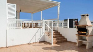 Terraço no telhado com piscina, churrasqueira e área de estar coberta.