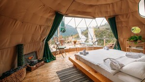 A cozy tent with a bed, a small table, and a chair. - Hill Inn (Keda)