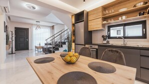 Een moderne keuken met houten kastjes, een inbouwoven en een raam boven de gootsteen.