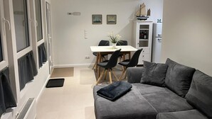 Ein gemütlicher Wohnbereich mit Essplatz, einer Couch und einem Schrank.