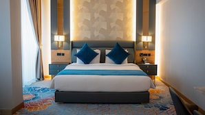 A hotel room with a large bed, two nightstands, a patterned wall, and a carpet with a geometric design. - La Zona Continental Hotel (Dubai)