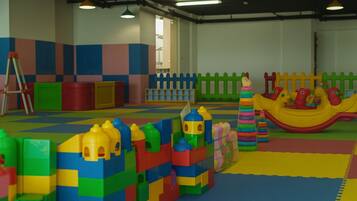 A play area with colorful building blocks, a slide, and a playhouse.
