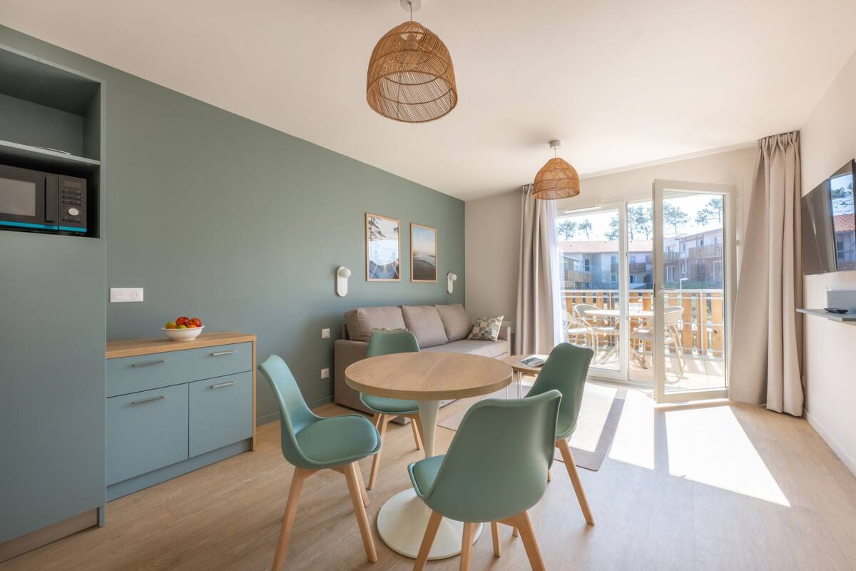Een moderne woonruimte met een eethoek, keuken en een balkon met uitzicht.