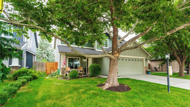A residential house with a well-maintained lawn, a large tree in front, and a garage. - Maple Suite Retreat: Arcade • Ping Pong • HomeGym • Toys • Pool • Playgrounds  (Meridian)