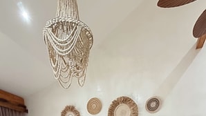 Egy modern nappali, melyben egy moduláris kanapé, egy kerek dohányasztal és egy rattan szék található.