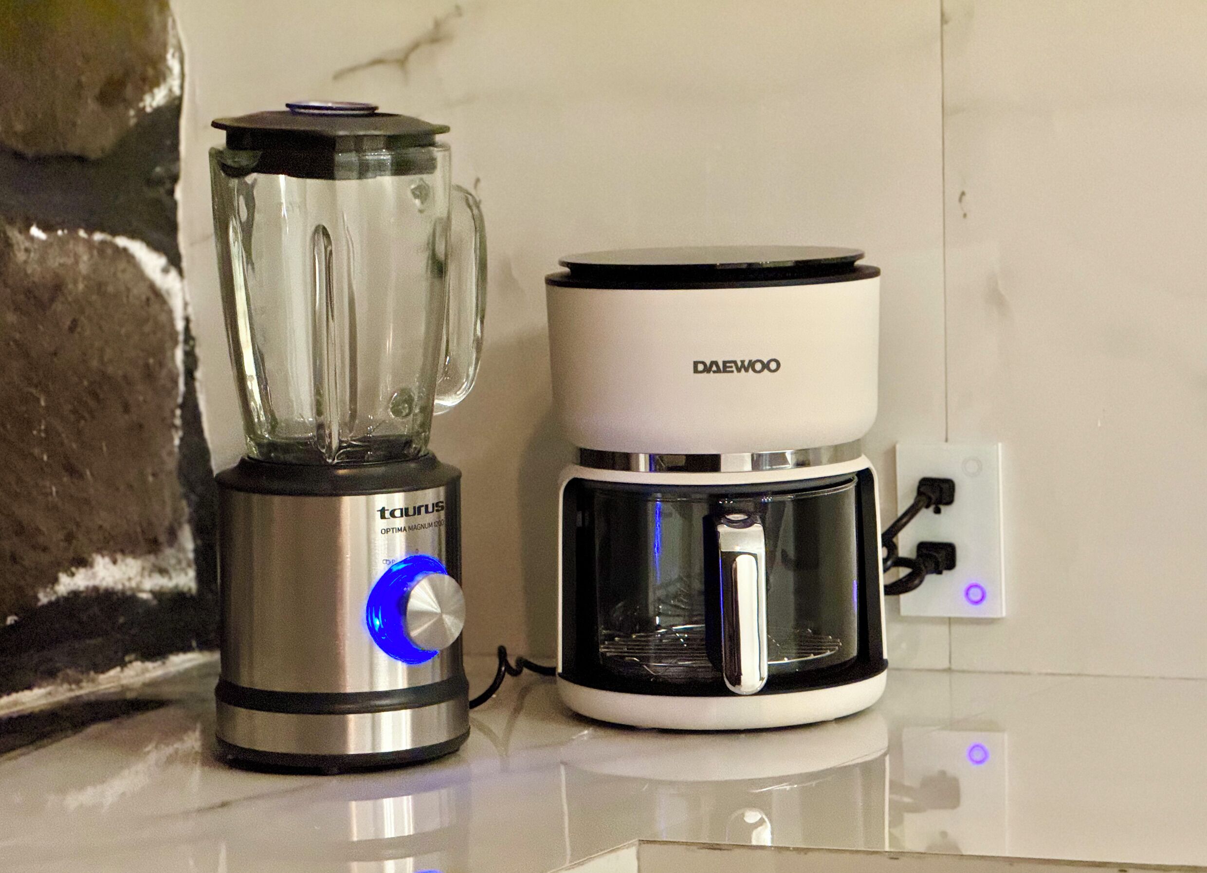 Una cocina con una licuadora y una cafetera sobre la encimera.