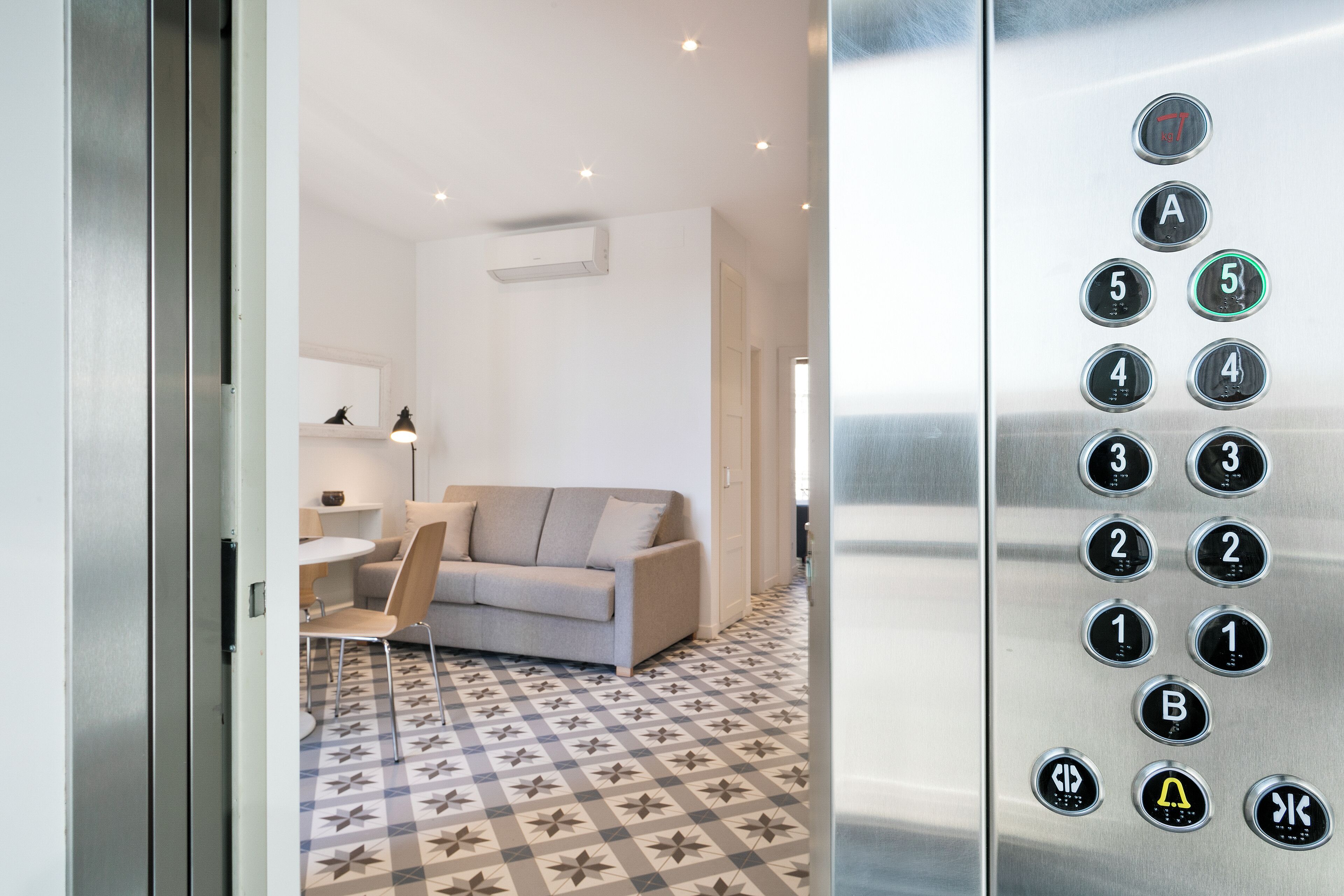 An elevator interior with a control panel displaying floor numbers and buttons.