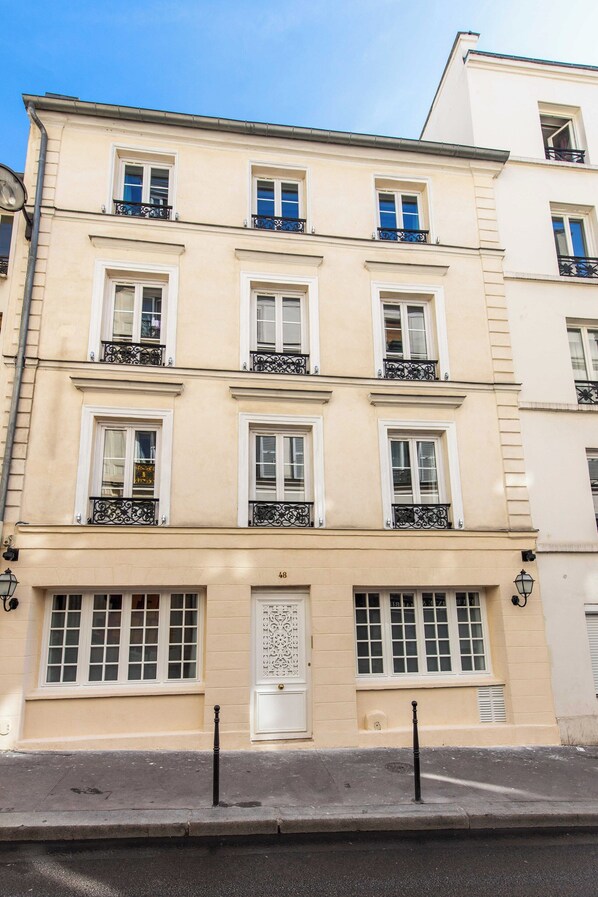 A multi-story building with a classic architectural style, featuring a symmetrical facade with evenly spaced windows and decorative iron railings on the balconies. - Elegant Studio - 1br/2p - Pigalle/sacre-coeur (Paris)