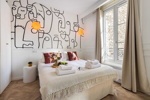 A modern bedroom with a large bed, a wall art piece, and a window with curtains. - Modern Studio - 2P - Pigalle / Moulin Rouge (Paris)