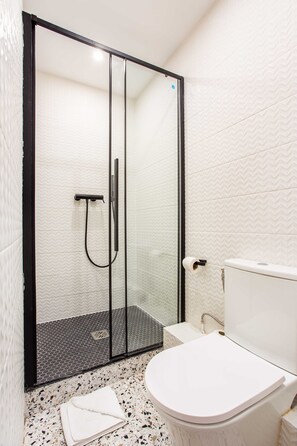 A bathroom with a glass-enclosed shower, a white toilet, and a tiled floor. - Elegant Apartment - 2BD /8P - Near Eiffel Tower (Paris)