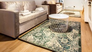 Ein modernes Wohnzimmer mit einer Couch, einem Couchtisch und einem gemusterten Teppich.