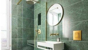 Une salle de bain équipée d’une douche, d’un lavabo, de toilettes et d’un miroir.
