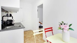 Una cocina compacta con un fregadero, estufa y un comedor con mesa y sillas.