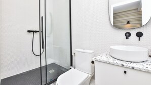 A modern bathroom with a glass shower enclosure, a white toilet, and a sink with a marble countertop. - Charming Studio - 2P- Javel/tour Eiffel (Paris)