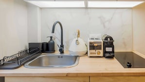 A modern kitchen with a stainless steel sink, a kettle, a toaster, and a coffee maker on the countertop. - Appartement in the Heart of Paris Eiffel Tower (Paris)