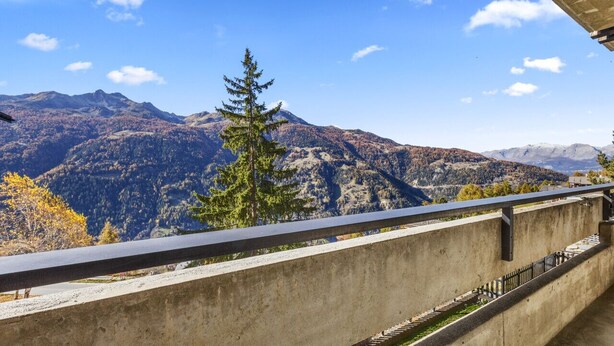 A concrete balcony with a metal railing overlooking a mountainous landscape. - Cosy studio with breathtaking view (Saint-Luc)