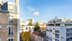 En byggnad med flera våningar som innehåller både bostäder och kommersiella lokaler, med balkonger och fri utsikt över det omgivande stadsområdet.