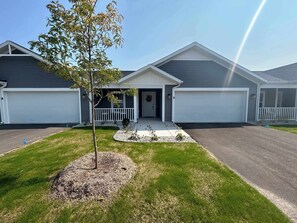 A two-story house with a front porch, a garage, and a driveway.