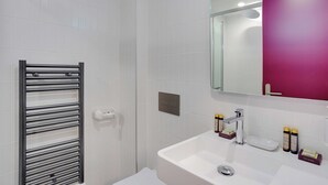 A bathroom with a white sink, a mirror, and a towel rack. - Intimate Studio - 2P - Republique (Paris)