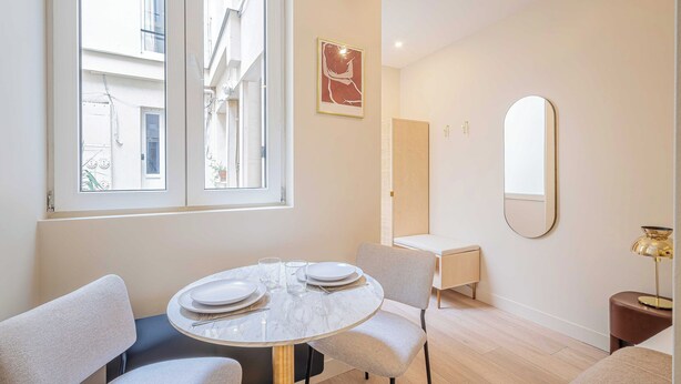 A dining area with a round table, chairs, and a window. - Cosy Studio for 2P - Le Bon Marche (Paris)