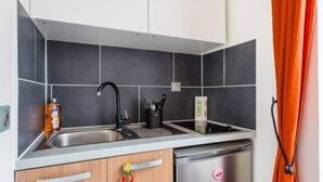 A compact kitchen with a sink, a dishwasher, and a cabinet with a handle. - Magnificent Studio - 2P - Pantin (Pantin)