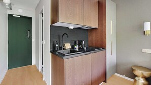 A modern kitchen with wooden cabinets, a black countertop, and a built-in stove. - Modern "green Suites" Residence - Meudon/velizy (Meudon)