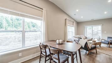 Amplia sala de estar con un gran comedor, asientos cómodos y ventanas grandes que ofrecen vistas al exterior.