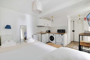 Una cucina moderna con forno a microonde, lavatrice e piano di lavoro in legno.