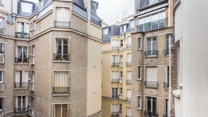 A multi-story residential building with balconies, large windows, and a brick facade. - Charming Apartment - 1br/4p - Passy (Paris)