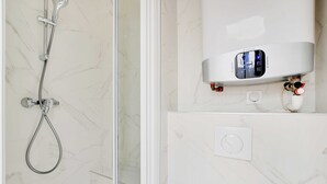Un baño con ducha, panel de control digital y calentador de agua.