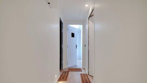Ένας διάδρομος με ένα χαλάκι καλωσορίσματος που οδηγεί σε μια πόρτα.