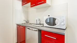 A compact kitchen with a microwave, a kettle, and a dishwasher. - Elegant Studio - 2P - Malakoff (Malakoff)