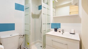 A modern bathroom with a glass shower enclosure, a white sink, and a mirror above the sink. - Magnificent Studio - 2P - Moulin Rouge (Paris)