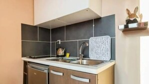 Ett kompakt kök med diskmaskin, diskho och spis.