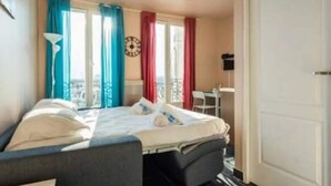 Ein Hotelzimmer mit Bett, Schreibtisch und Stuhl.