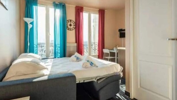 Ett hotellrum med en säng, ett skrivbord och en stol.