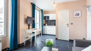 Un espace de vie compact comprenant un coin repas, une kitchenette et un canapé.