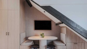 Un rincón acogedor con una mesa redonda, dos sillas y un mueble bajo.