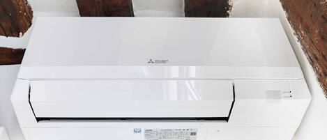 A Mitsubishi air conditioning unit mounted on a white wall.