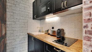 A kitchen with a wooden countertop, a sink, a toaster, and a coffee maker. - The Wizard's Studio! (Paris)