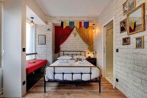 A room with a bed, a red bench, a mirror, and a wall with a brick pattern. - The Wizard's Studio! (Paris)