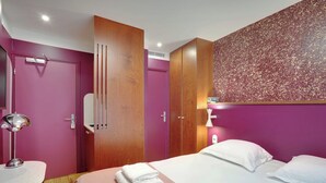 Una camera d'albergo con un letto, una scrivania e un armadio.