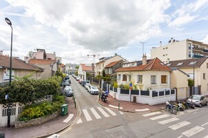 Una calle residencial con casas, coches aparcados y un paso de peatones.