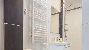 Une salle de bain moderne équipée de toilettes, d’un lavabo et d’une douche.