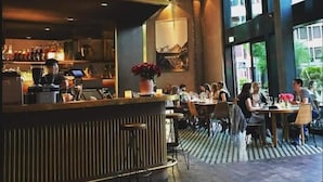 Un restaurant doté d’un bar, de grandes fenêtres et d’un décor intérieur moderne.