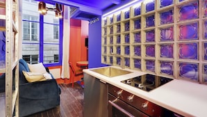 Een moderne keuken met een ingebouwde oven, een roestvrijstalen spoelbak en een glazen spatwand.