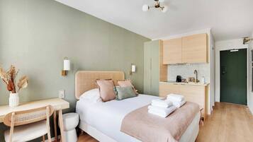 Laptop workspace, iron/ironing board, bed sheets