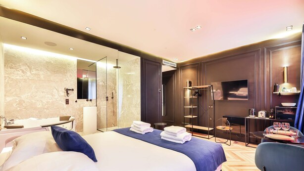 A modern hotel room with a large bed, a separate bathroom, a seating area, and a flat-screen TV. - Wonderful Private Room - 2P - Chatelet (Paris)